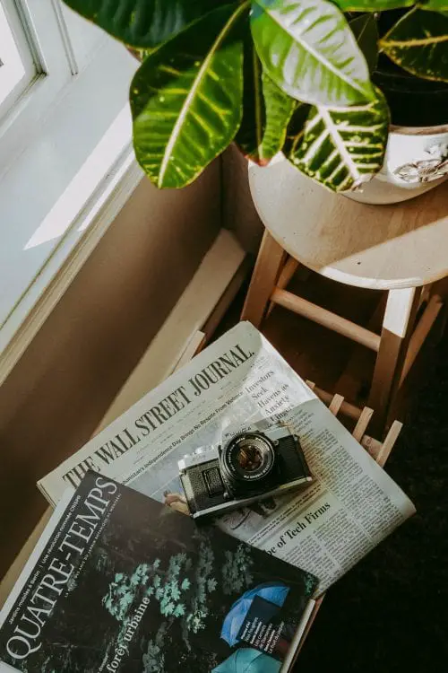 black and silver camera on newspaper