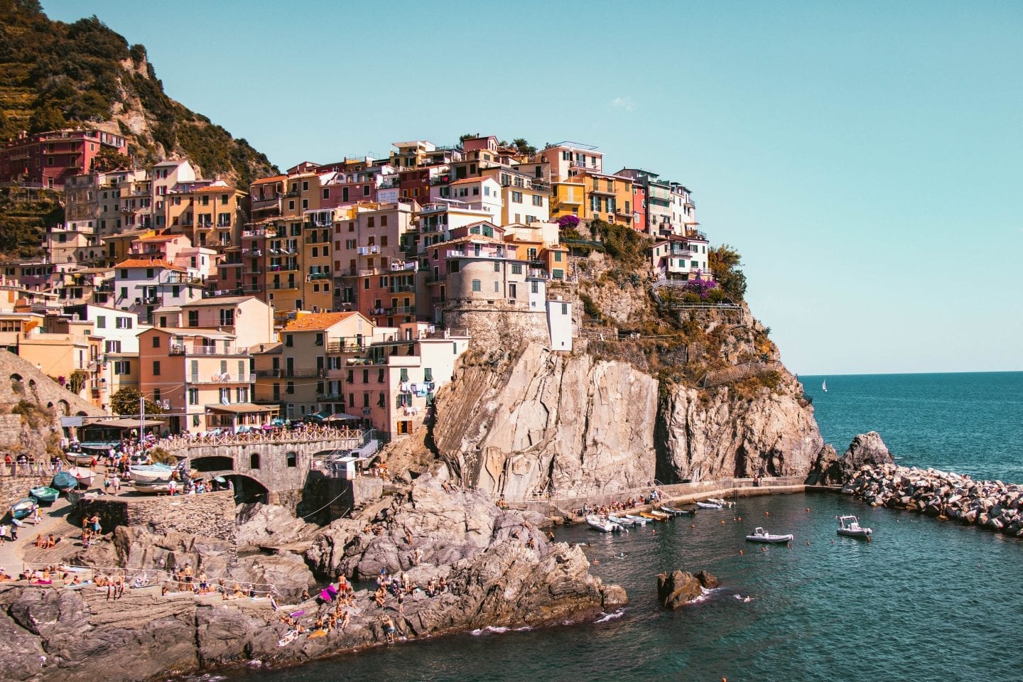 Colorful houses on a cliff with sea below - Cinque Terre Village of Manarola, Italy - Day Trip from Milan