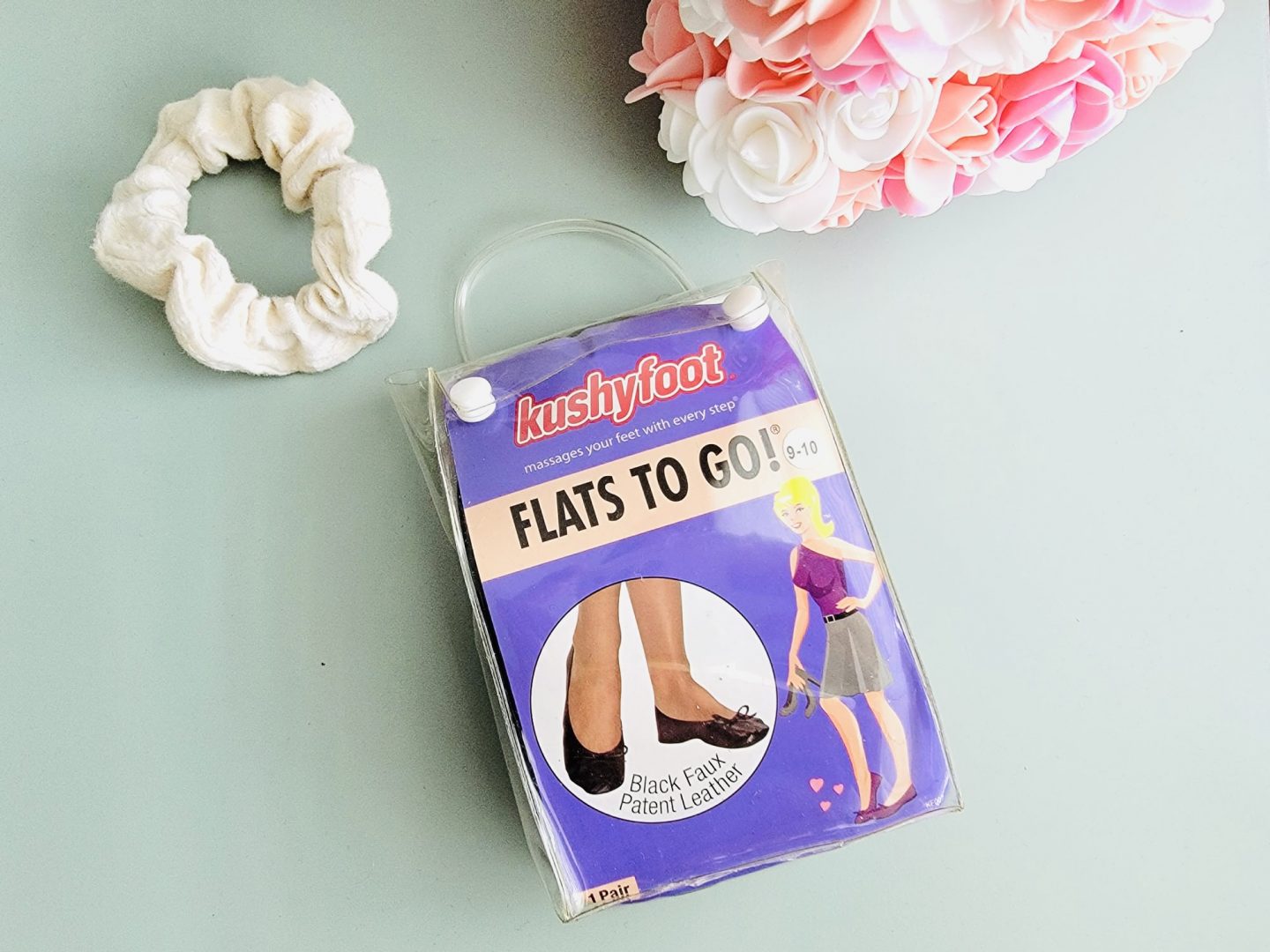 Flat shoes in plastic packaging on blue background