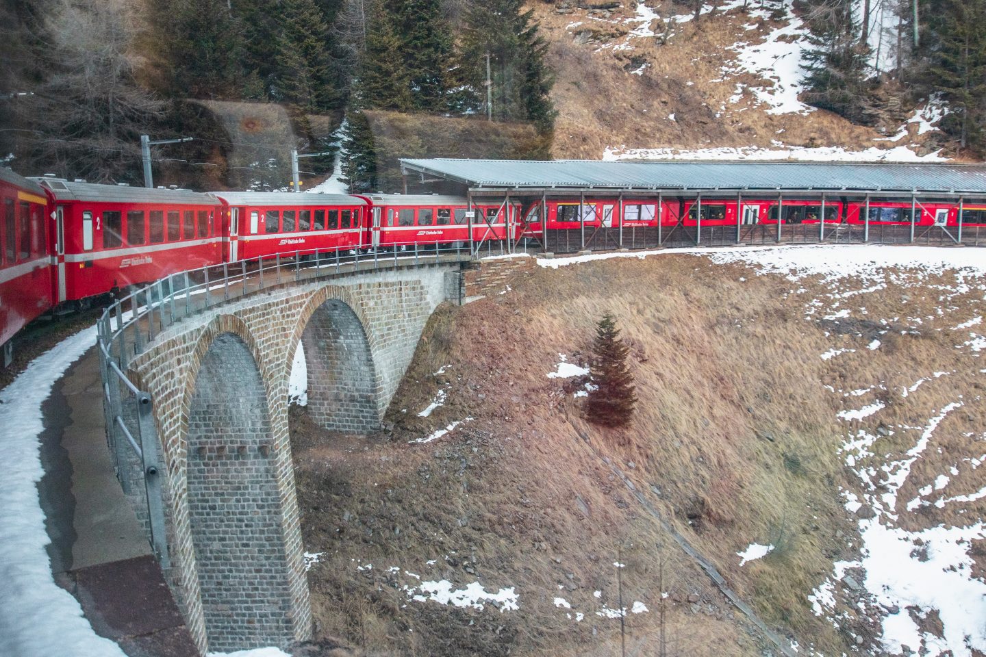 Red train crossing circular viaduct