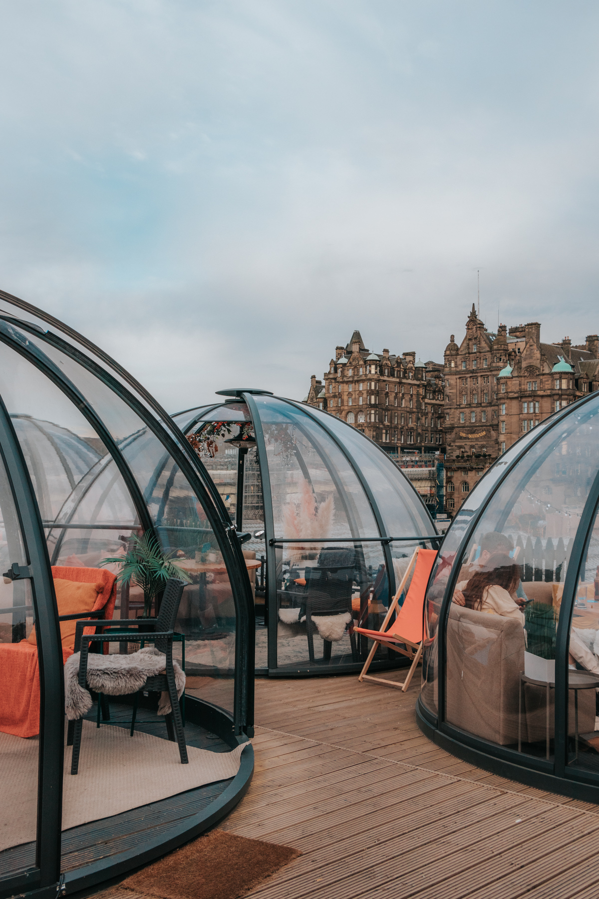 Glass domes made for dining in front of historical city buildings - Cask Smugglers in Edinburgh, Scotland